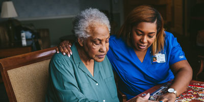 Caregiver looking through a photo album with an older woman